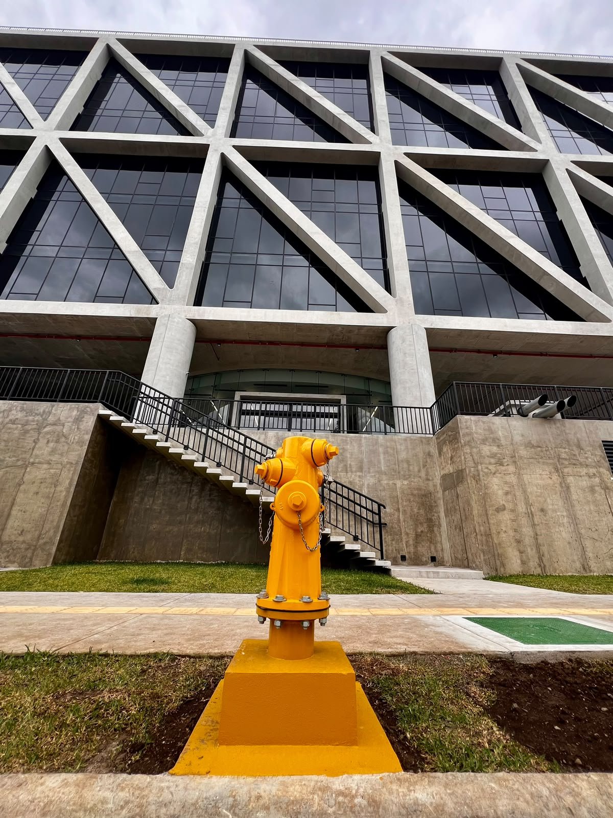 Hidrante amarillo instalado frente a la fachada de un edificio